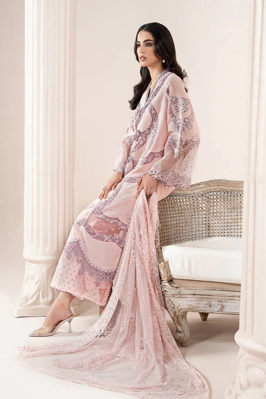 Woman in a pink floral dress sitting on a wicker chair in a decorated room.