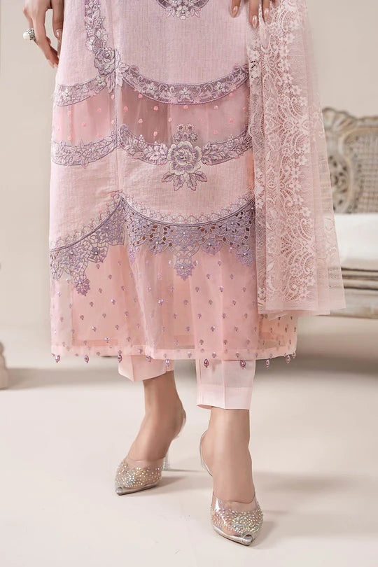 Pink embroidered traditional outfit with silver shoes on a white background