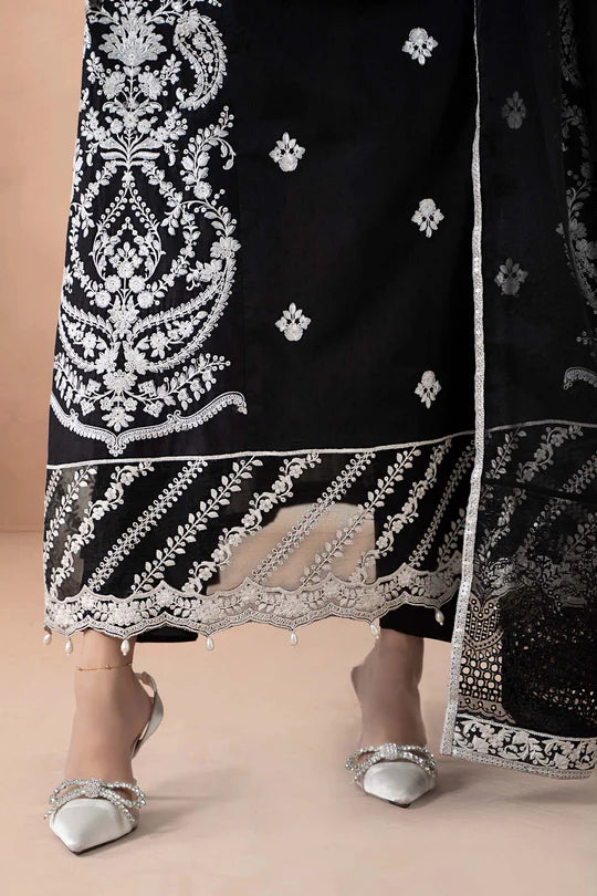 Black traditional outfit with white embroidery on a beige background