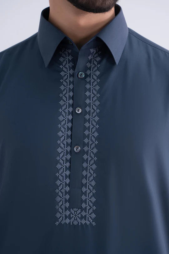 Navy blue shirt with intricate white embroidery on a plain background
