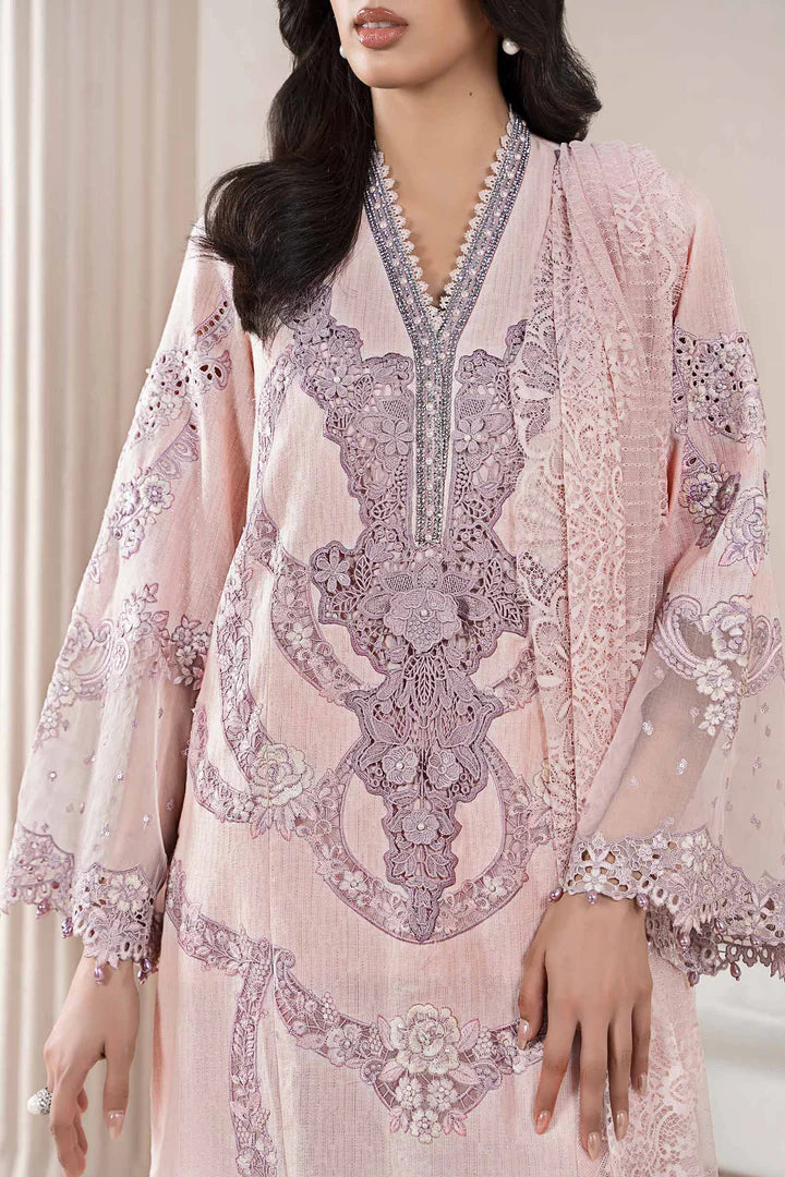 Woman wearing a pink embroidered dress with intricate patterns