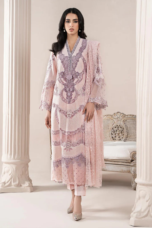 Woman wearing a pink and purple embroidered traditional outfit in an elegant room.