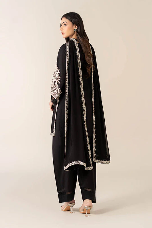 Woman wearing a black traditional outfit with white embroidery on a beige background