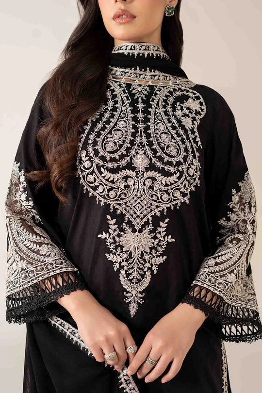 Black outfit with intricate white embroidery on a plain background