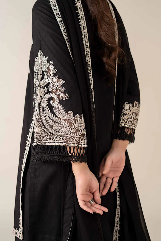 Black embroidered garment with intricate patterns on a plain background