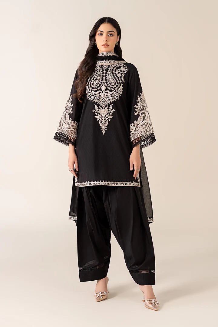 Woman wearing a black embroidered outfit with white patterns on a beige background
