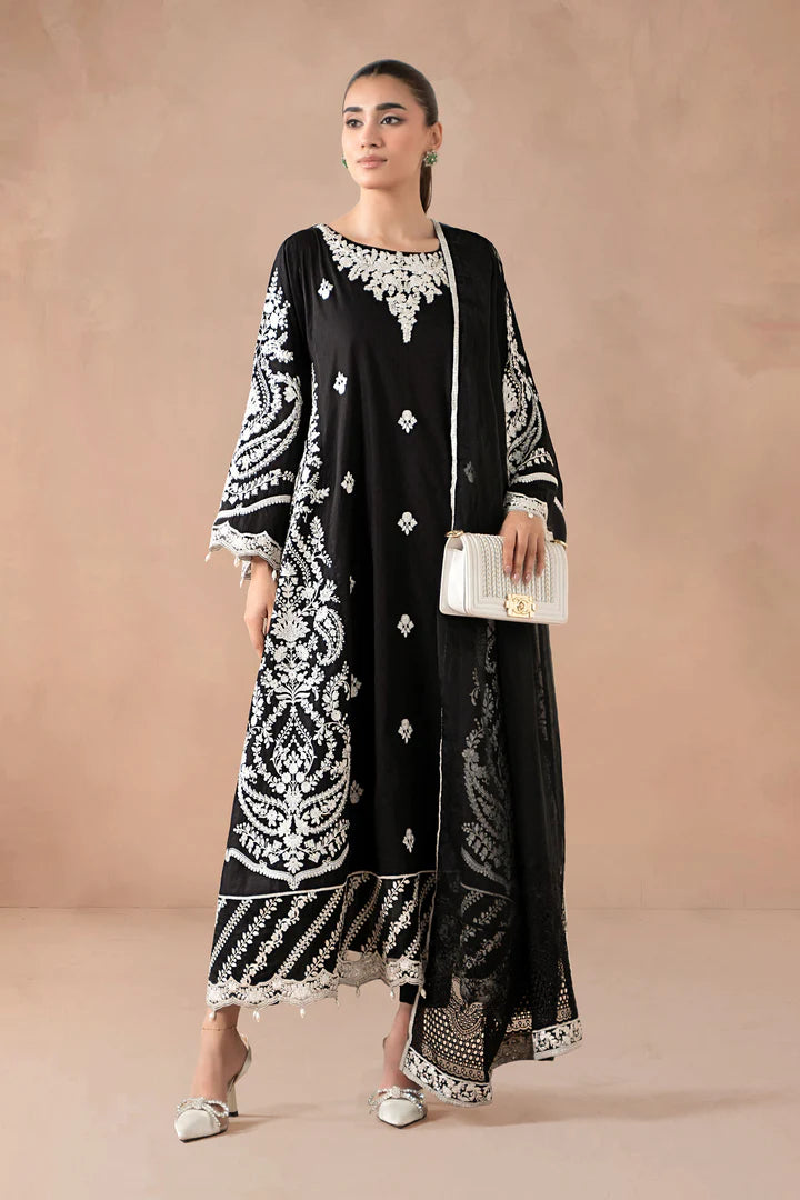 Woman wearing a black and white embroidered outfit against a beige background
