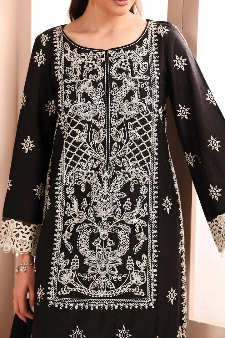 Black embroidered dress with white patterns on a neutral background