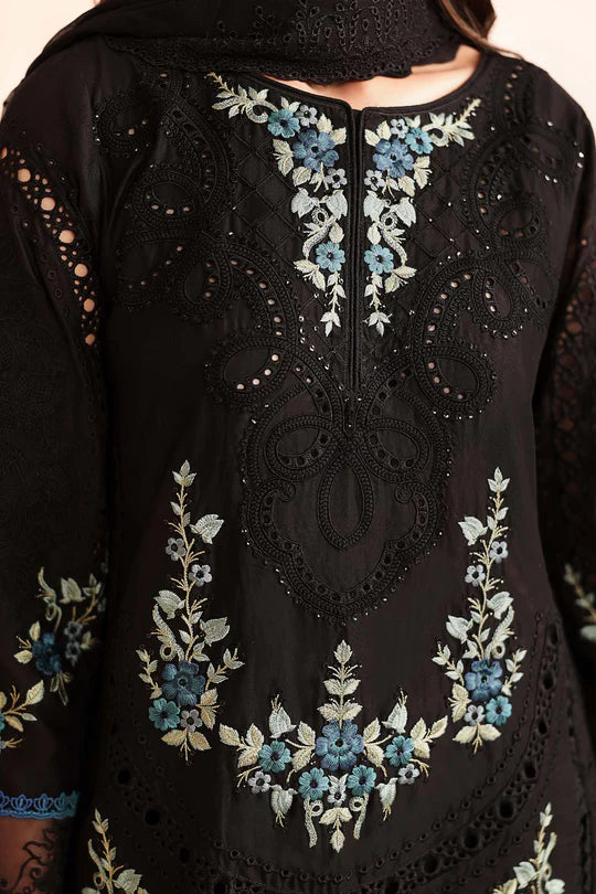 Black embroidered garment with floral patterns on a neutral background