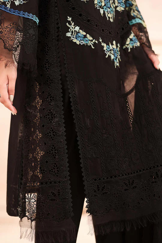 Black embroidered garment with floral patterns on a beige background