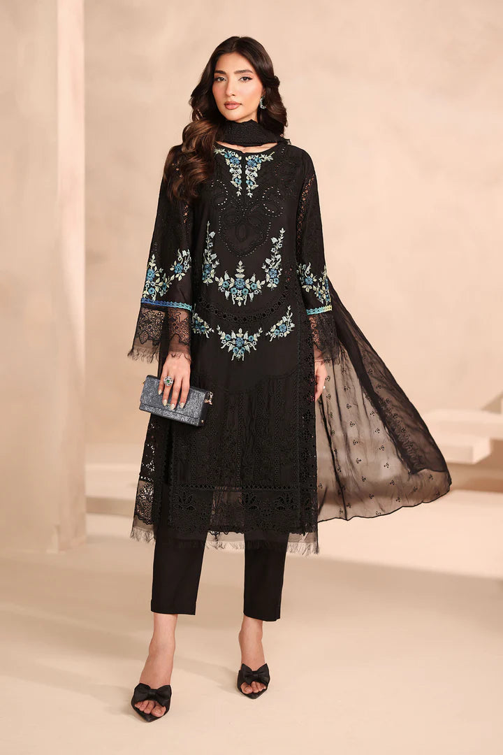 Woman wearing a black embroidered outfit with a sheer dupatta on a beige background
