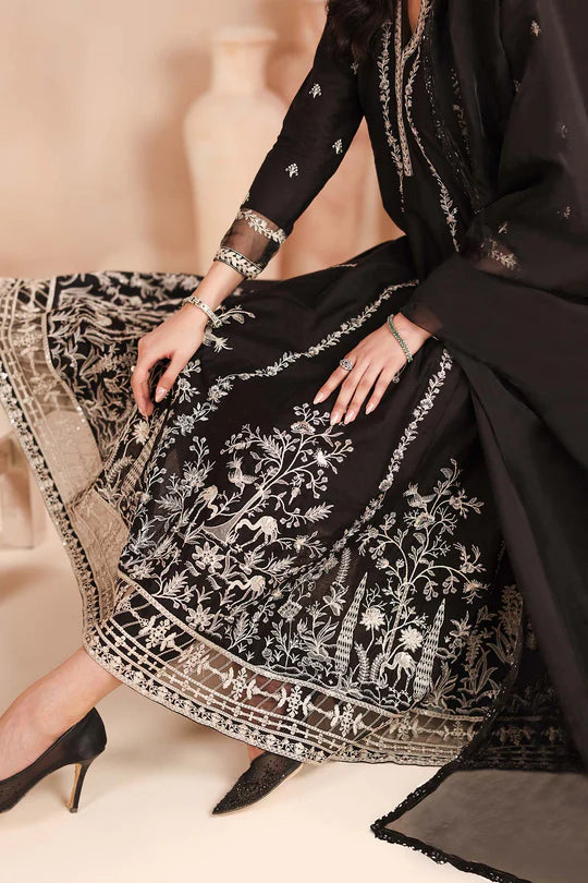 Black embroidered traditional outfit with intricate patterns on a beige background