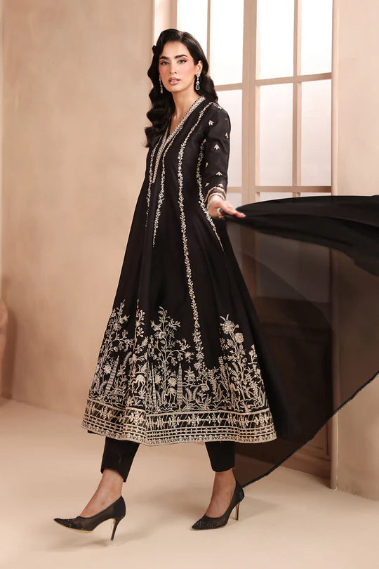 Woman wearing a black embroidered anarkali suit in a neutral setting