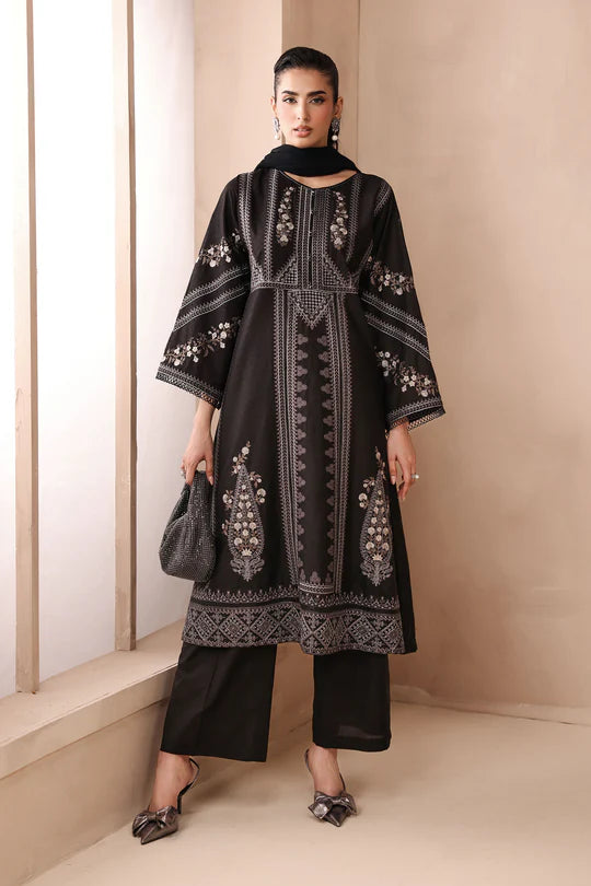 Woman wearing a black embroidered outfit with a plain background