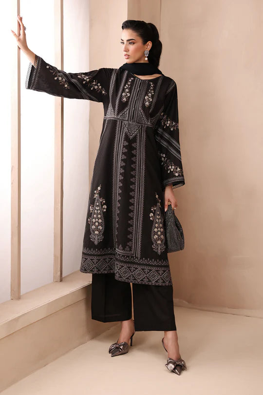 Woman wearing a black embroidered outfit in a minimalistic setting