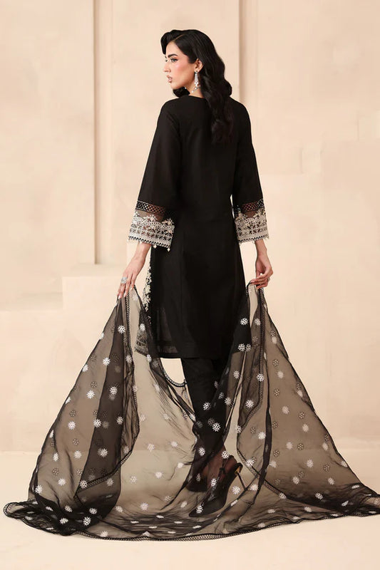 Woman wearing a black outfit with a sheer dupatta against a beige background