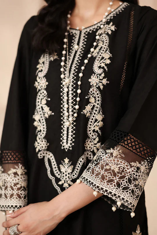 Black garment with intricate white embroidery on a neutral background
