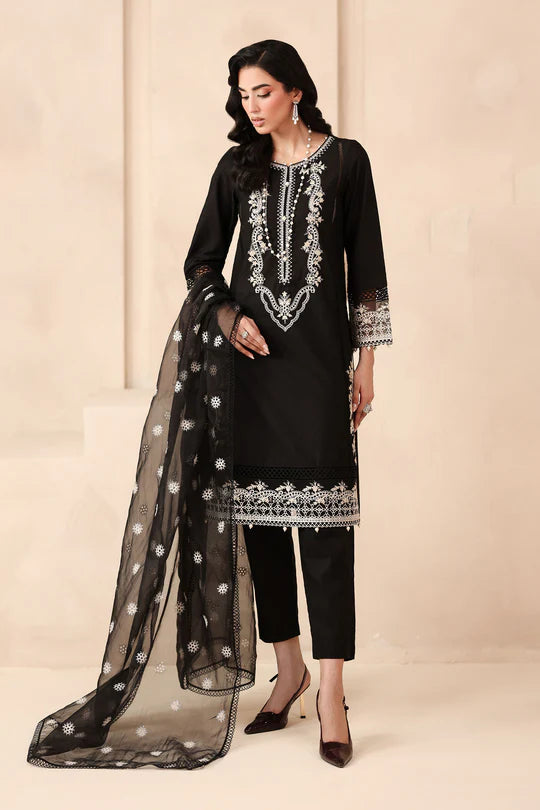 Woman wearing a black embroidered outfit with a sheer dupatta on a beige background