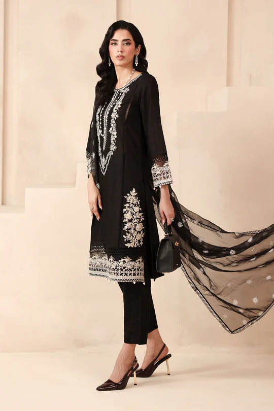 Woman wearing a black embroidered outfit with a beige background