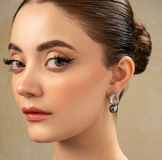 Close-up of a woman wearing earrings with a neutral background
