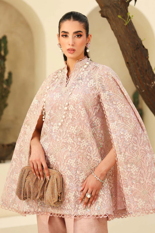 Woman wearing a pink embroidered outfit with a beige background