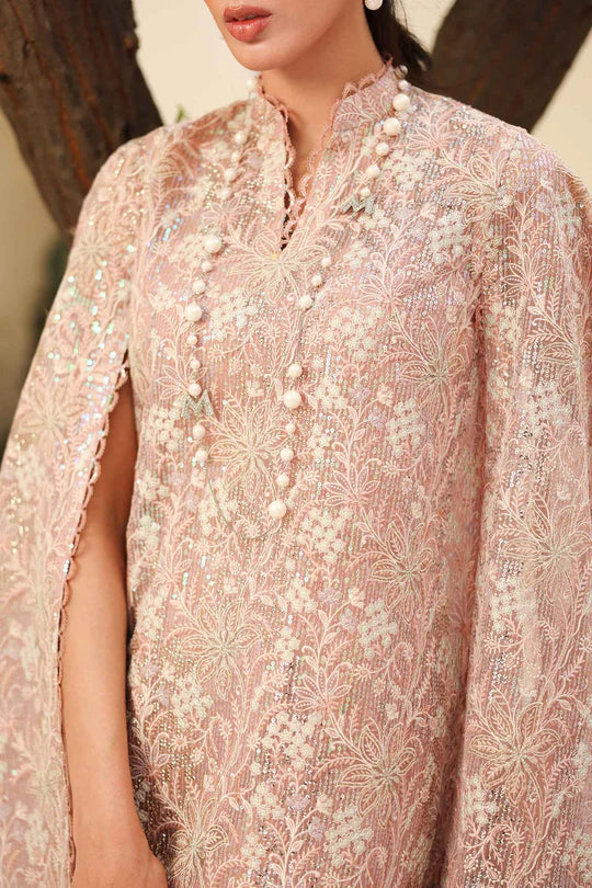 Close-up of a person wearing a pink embroidered traditional outfit with a blurred background