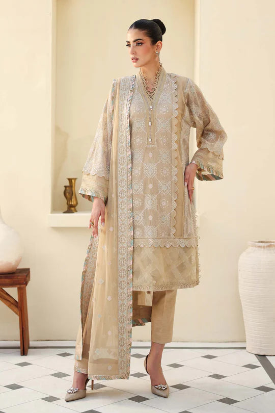 Woman wearing a beige embroidered outfit in a room with decorative elements.