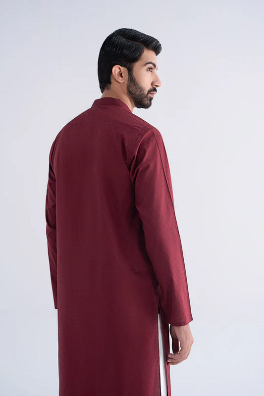 Man wearing a burgundy traditional outfit on a white background